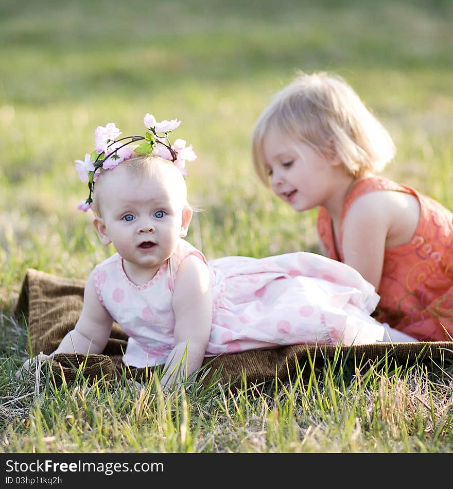 Two little girls sitting on the grass