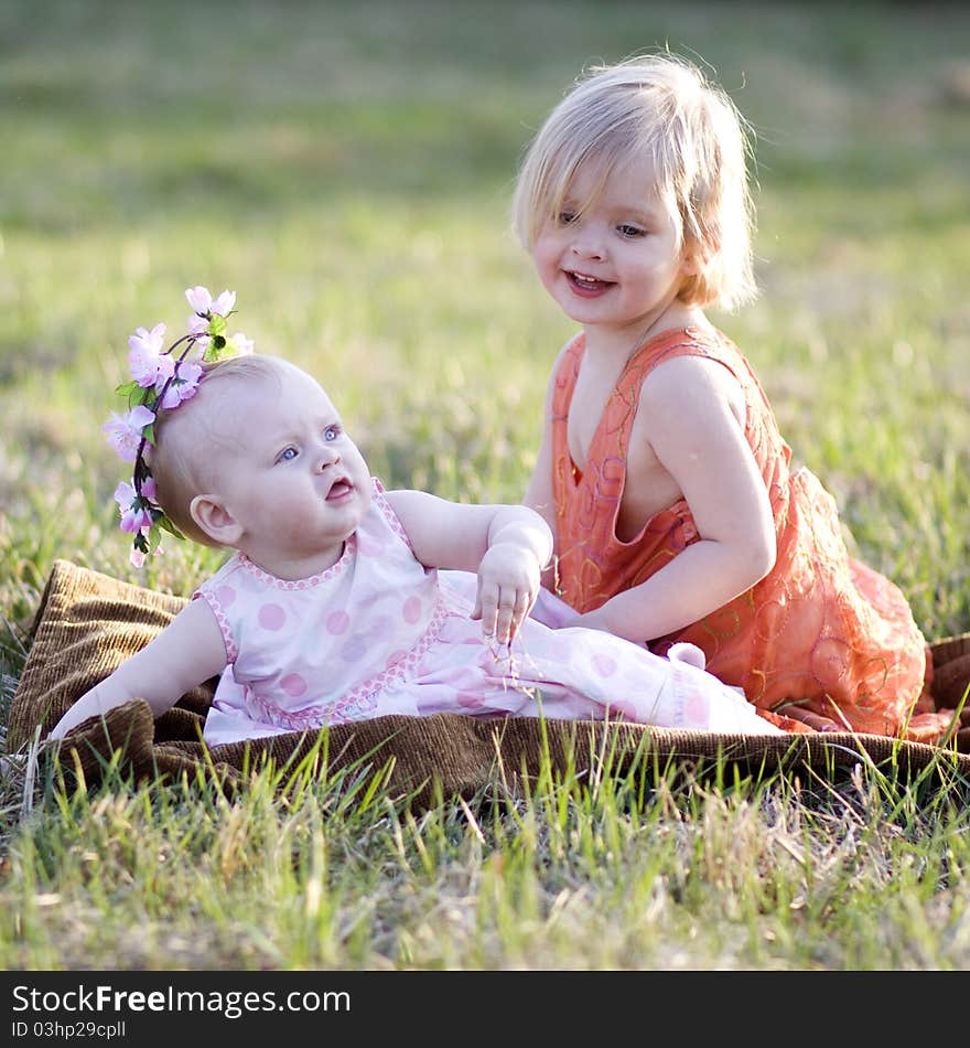 Two little girls sitting on the grass