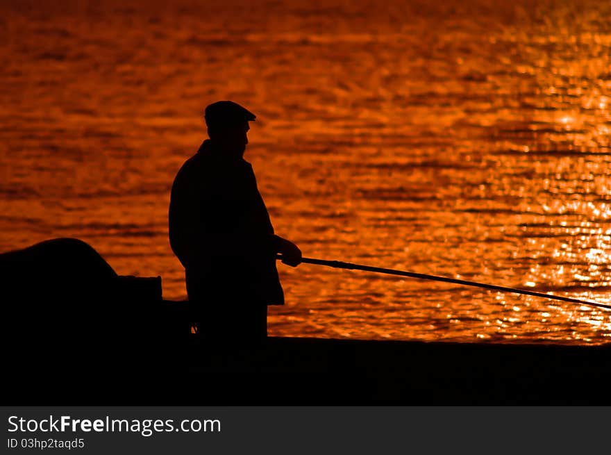 Man fishes on the sea before sunset. Man fishes on the sea before sunset.