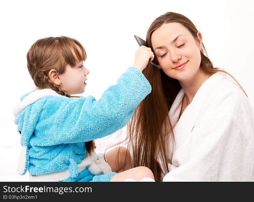 Beautiful young mother and her five year old daughter on the bed at home. Beautiful young mother and her five year old daughter on the bed at home