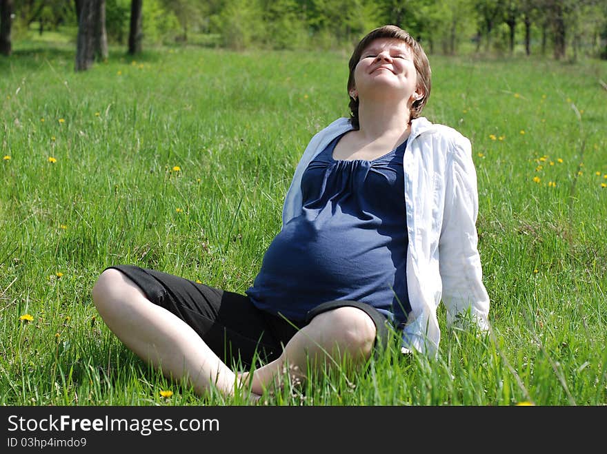 Sunny spring day. A pregnant woman relaxing outdoors. Sunny spring day. A pregnant woman relaxing outdoors