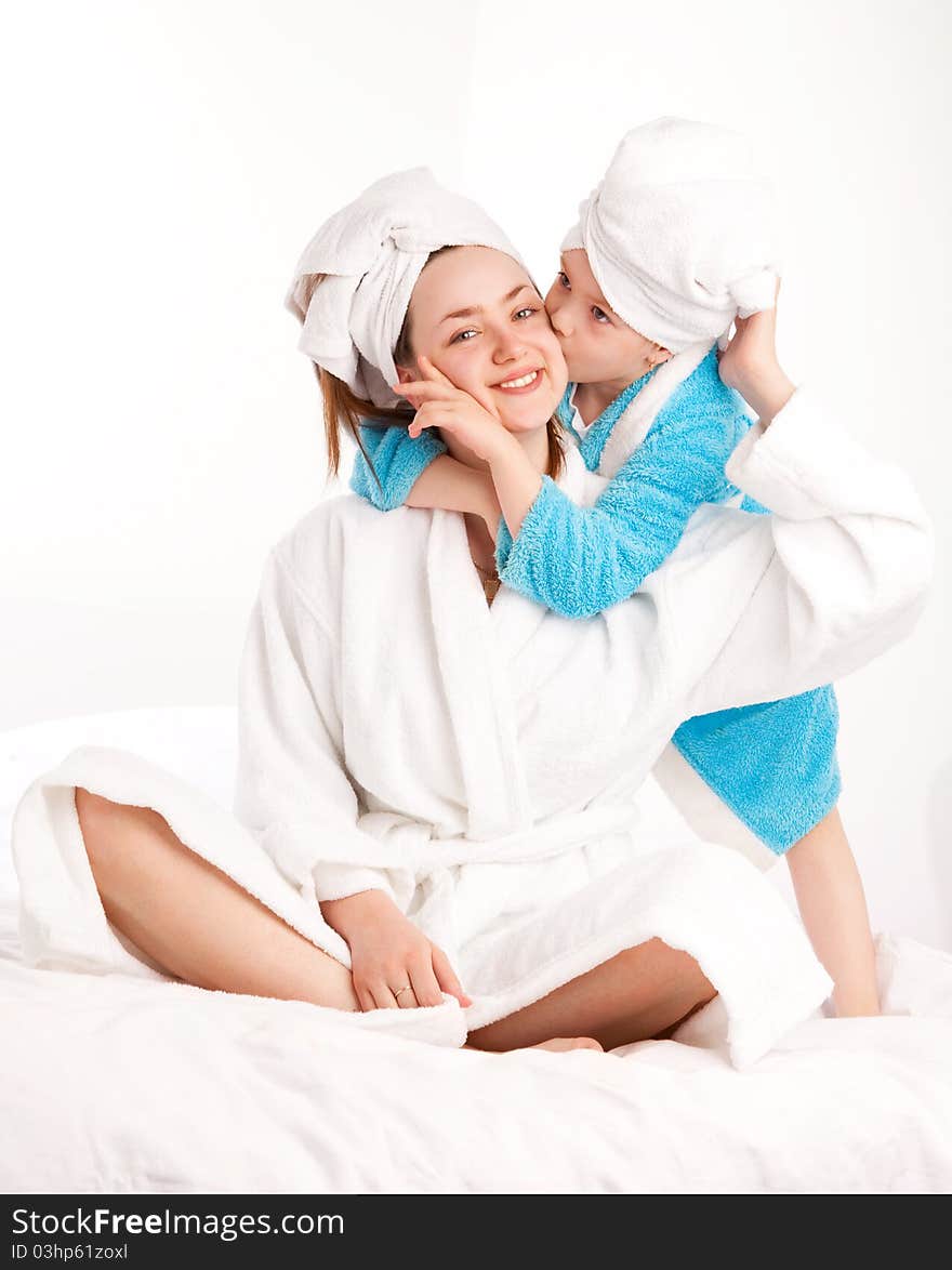 Beautiful young mother and her five year old daughter on the bed at home. Beautiful young mother and her five year old daughter on the bed at home