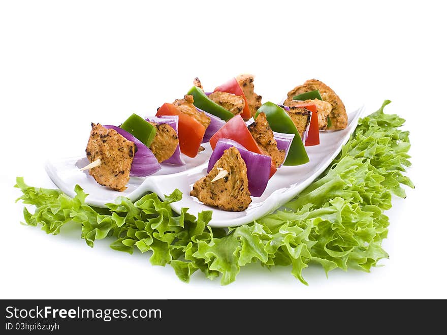 Skewers with chicken and vegetables on the plate - isolated. Skewers with chicken and vegetables on the plate - isolated