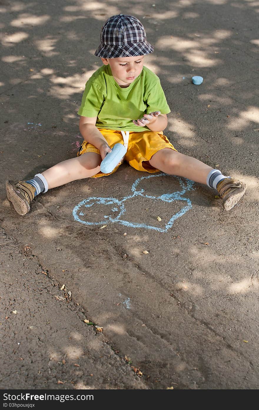 Boy drawing with chalk on asphalt