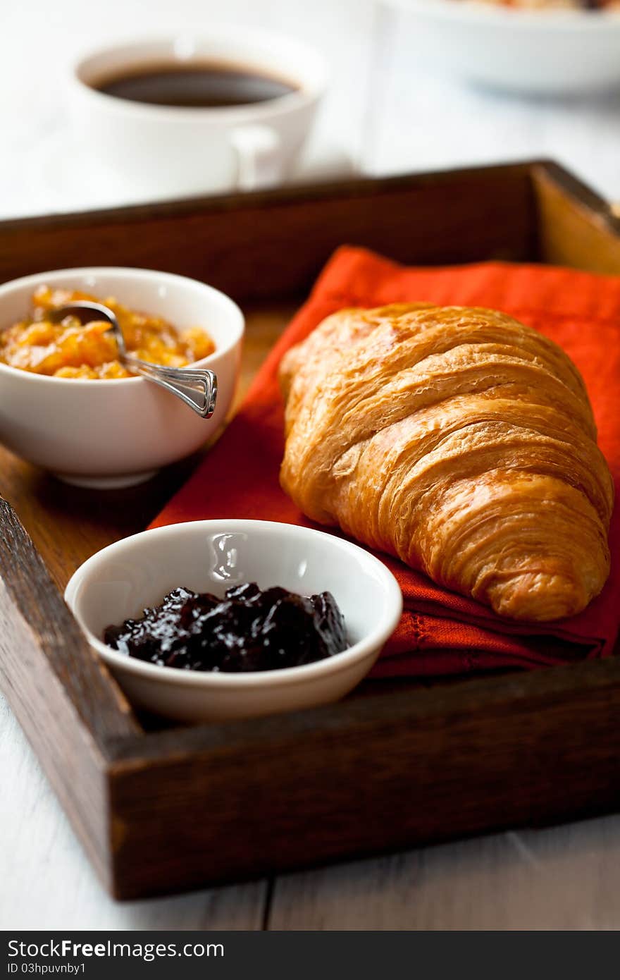 Closeup of french croissant on a rustic wooden tray. Closeup of french croissant on a rustic wooden tray