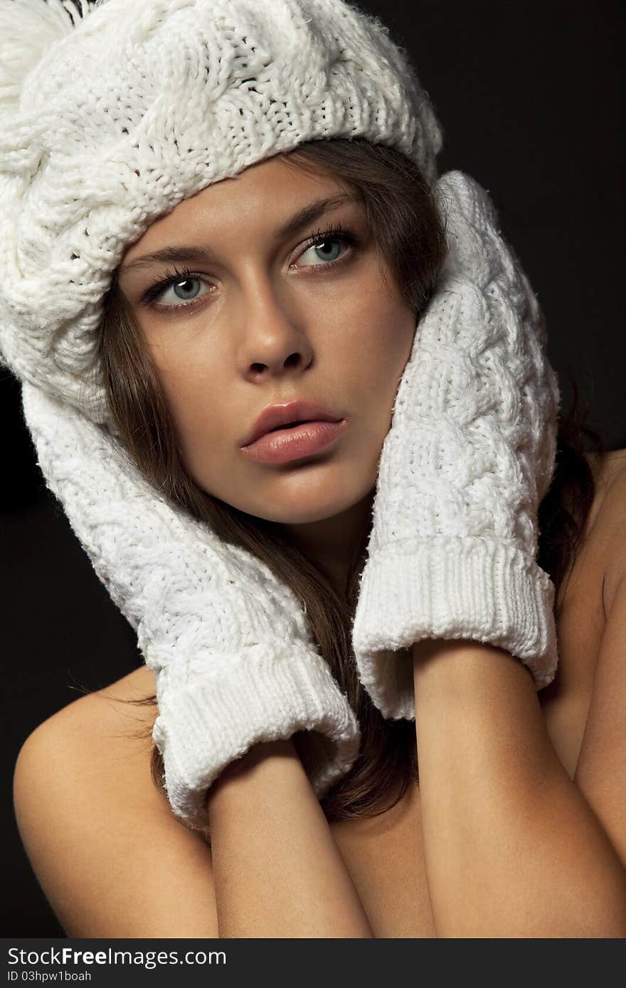 Woman in knit white mittens and cap