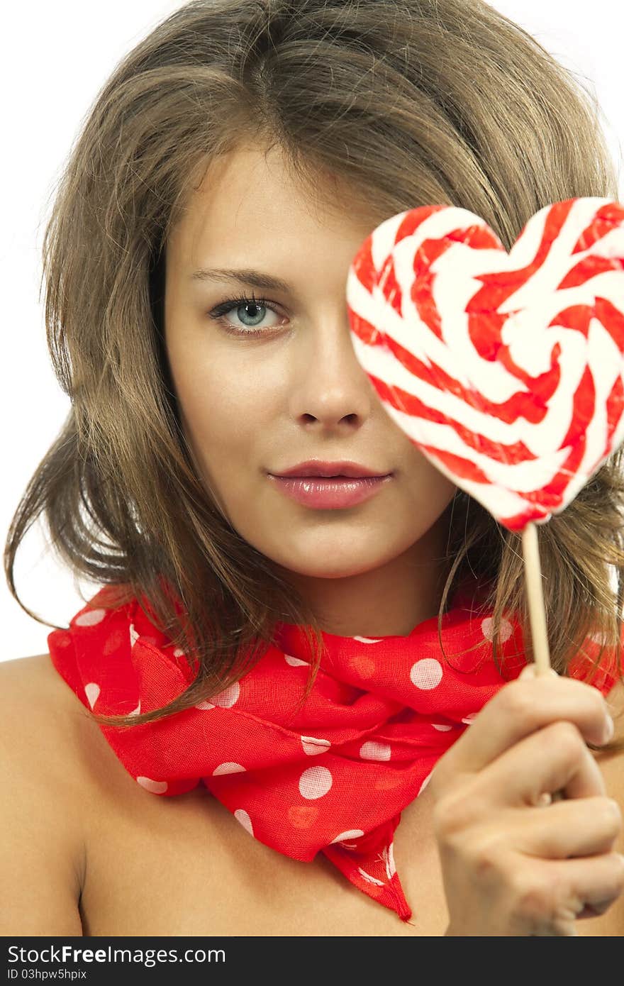 Close-up portrait of young woman with heart shaped lollipop