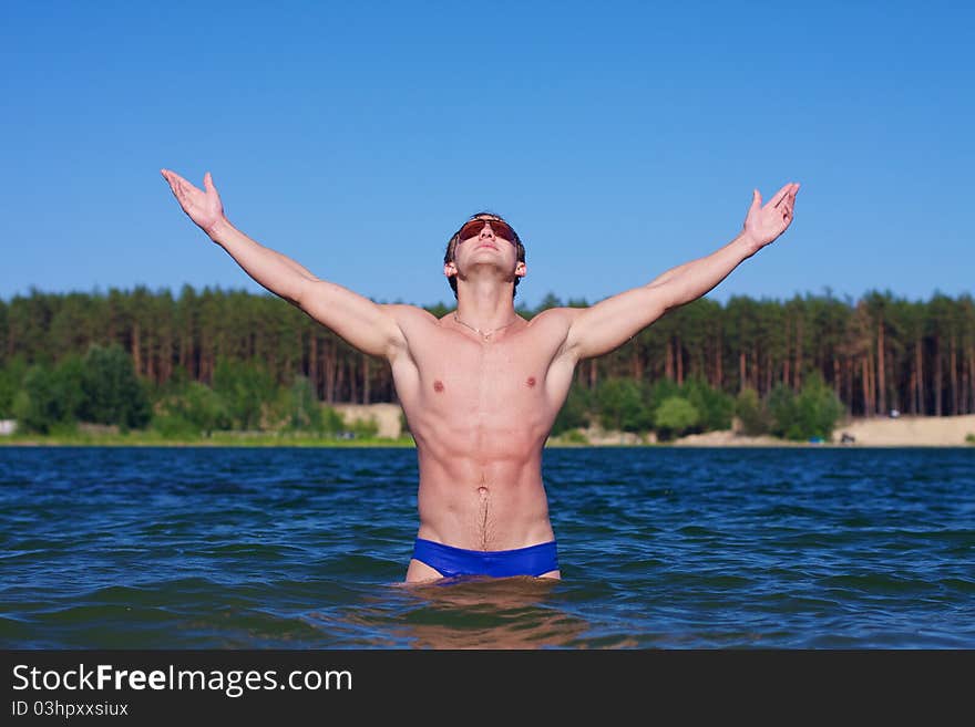 Young athletic man posing in the water