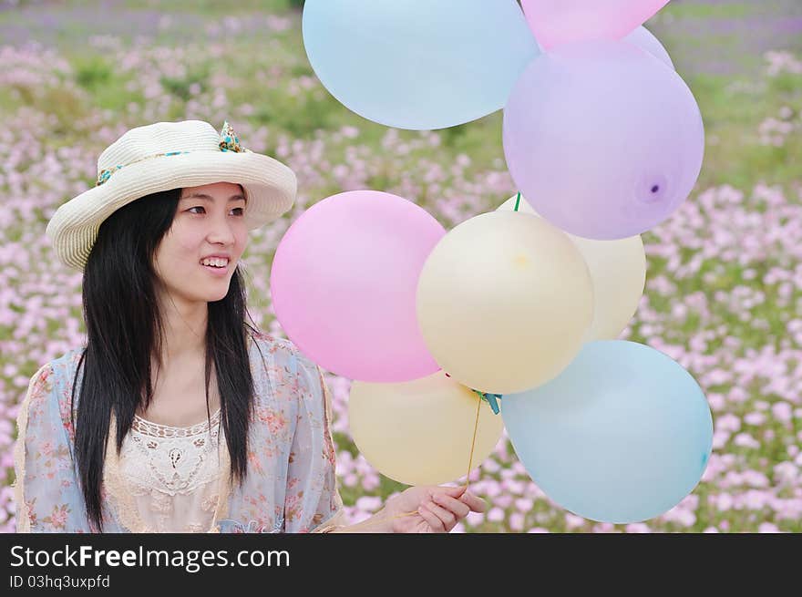 A girl is smiling with balloons in hand. A girl is smiling with balloons in hand