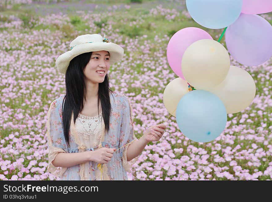 A girl is smiling with balloons in hand. A girl is smiling with balloons in hand