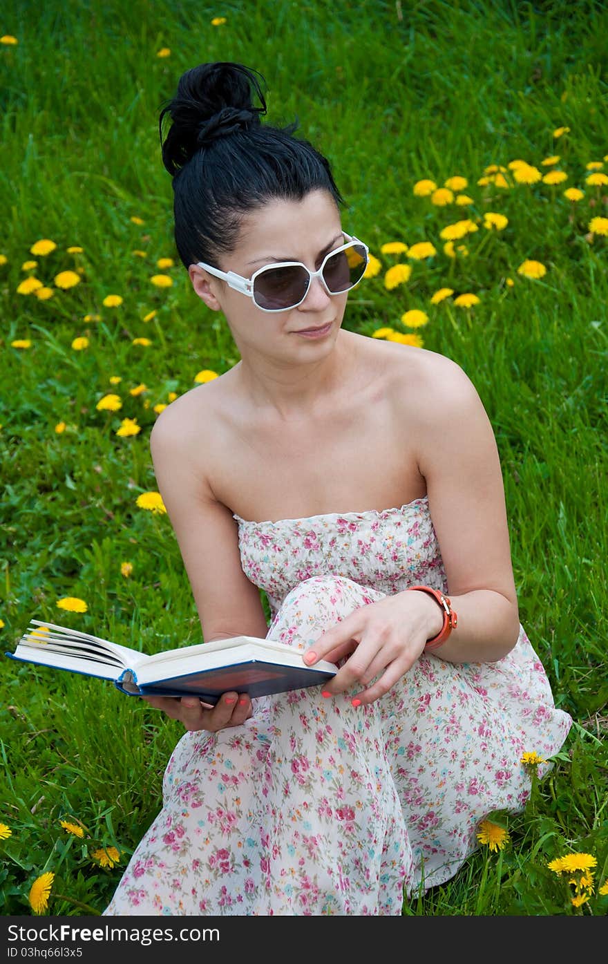 Young woman reading a book in the park