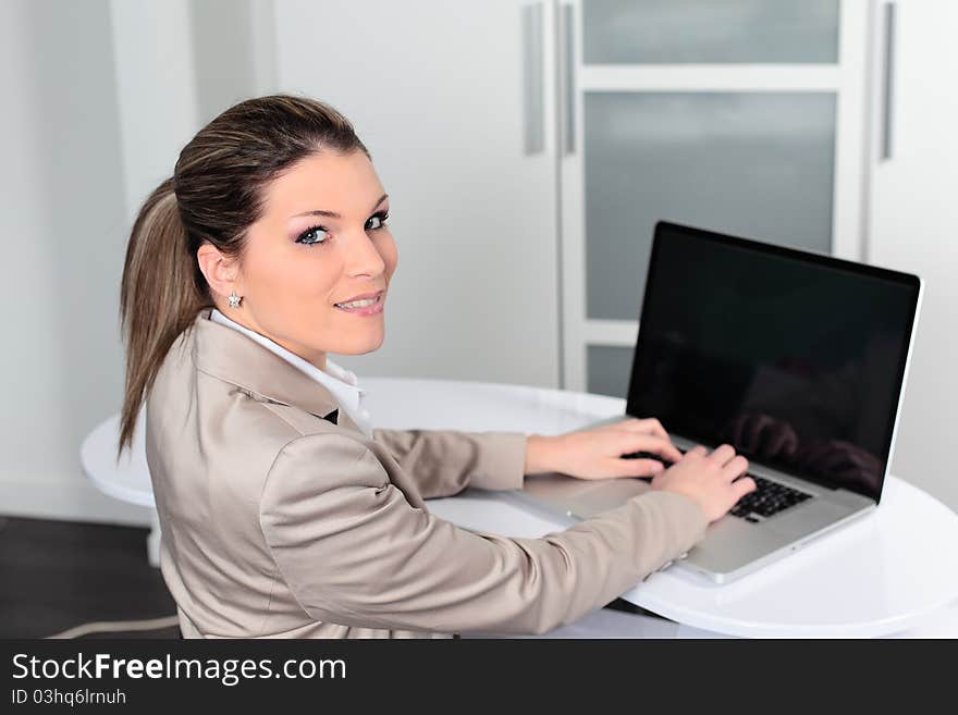 Young businesswoman with computer in office