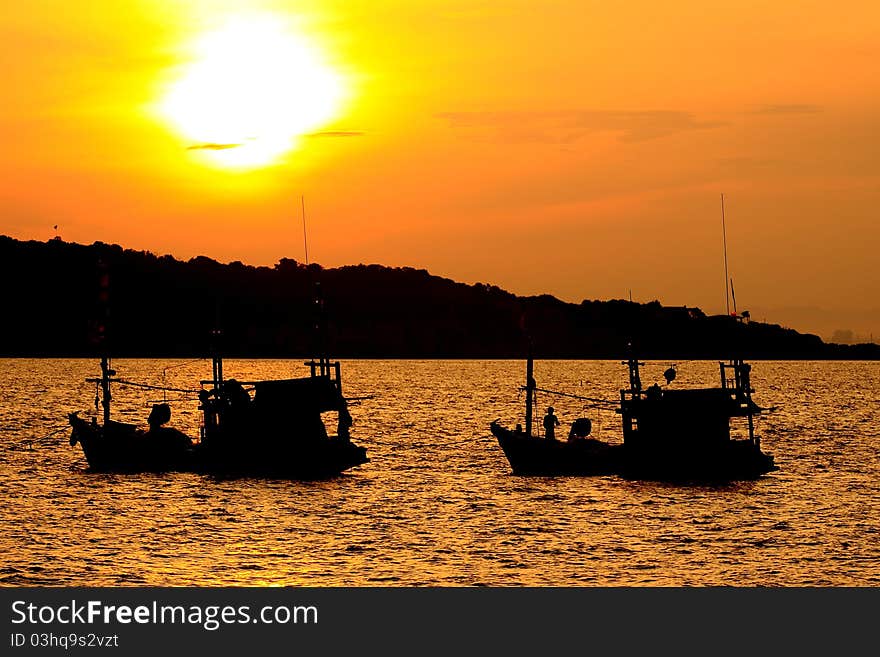 Fishing boat with two aircraft shot backlit.