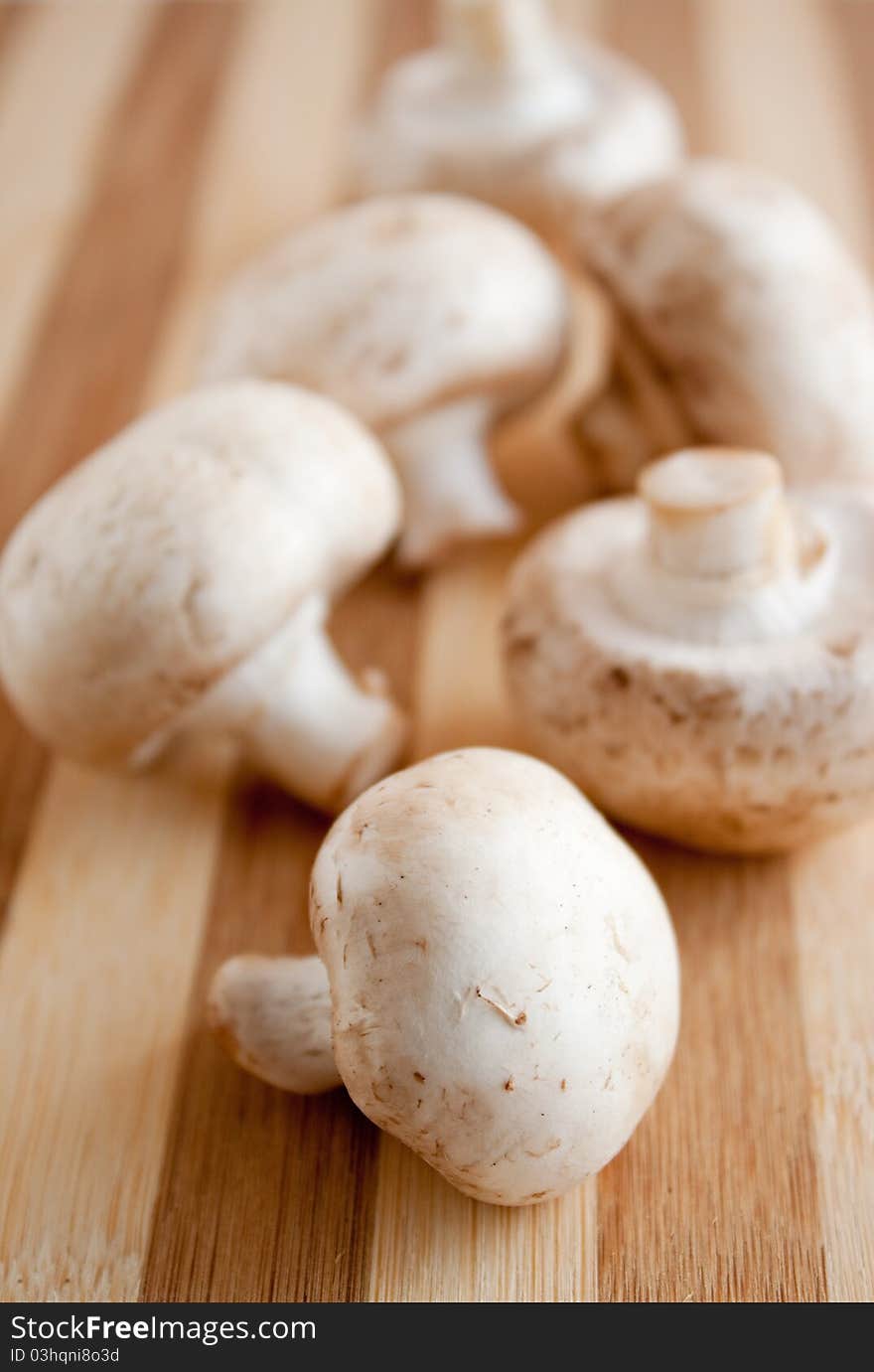 a pile of chestnut mushrooms  on a wooden brown board