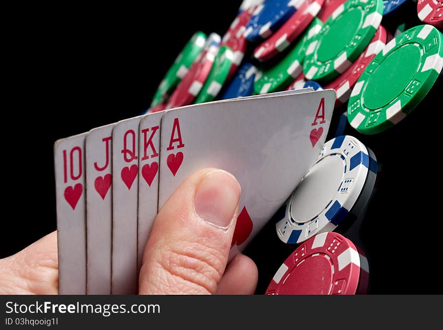 Royal flush and poker chips on a black background