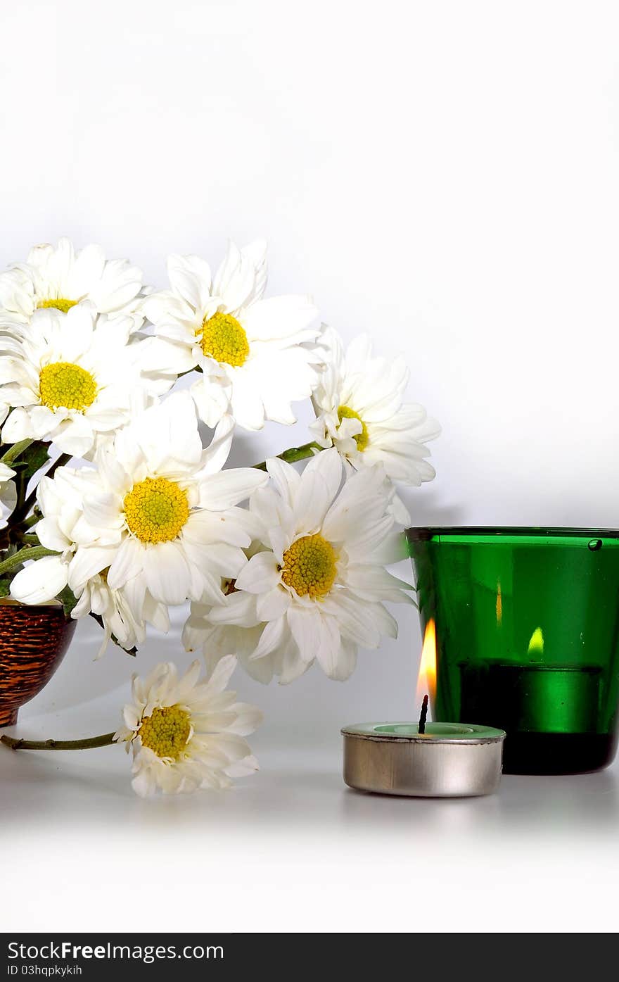 Simple white daisies and two candles with isolated white background