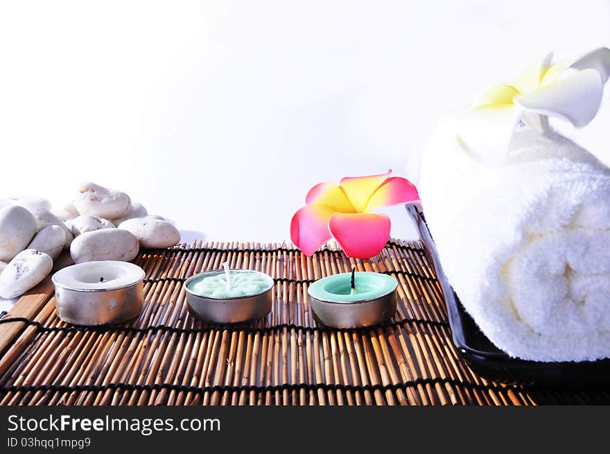 Three candles and one white towels on bamboo mat. Three candles and one white towels on bamboo mat