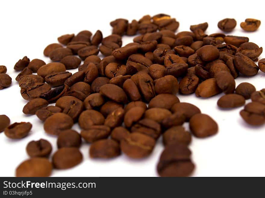 Scattered grains of black coffee isolated on white