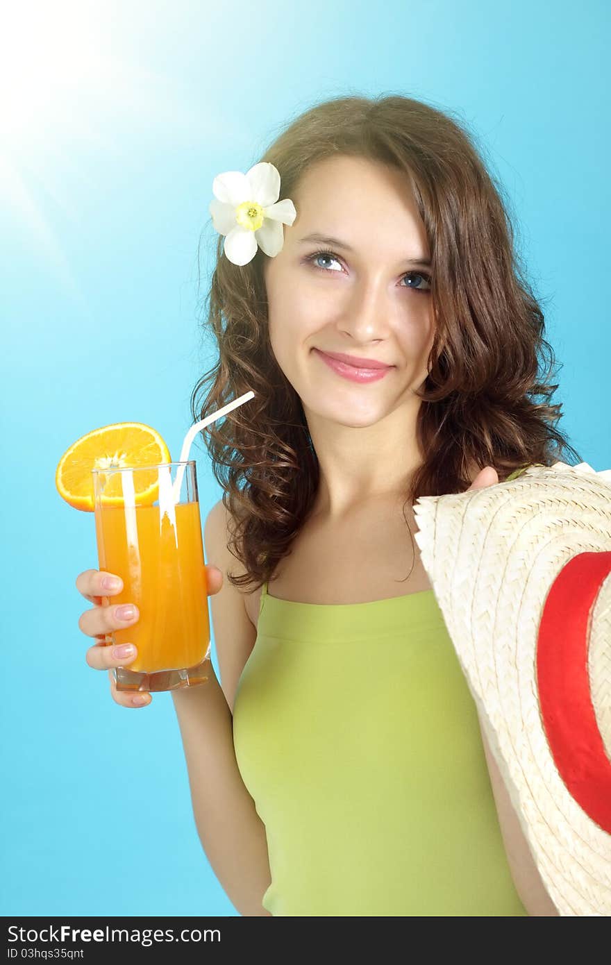 Girl holding a glass of juice on a blue background