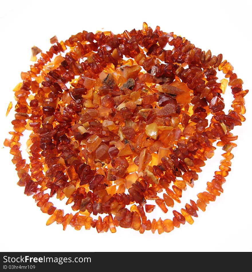 Stones of amber and a necklace on white background. Stones of amber and a necklace on white background