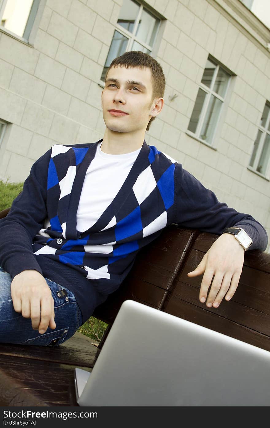 Close-up of a young male student with a laptop on campus. Close-up of a young male student with a laptop on campus