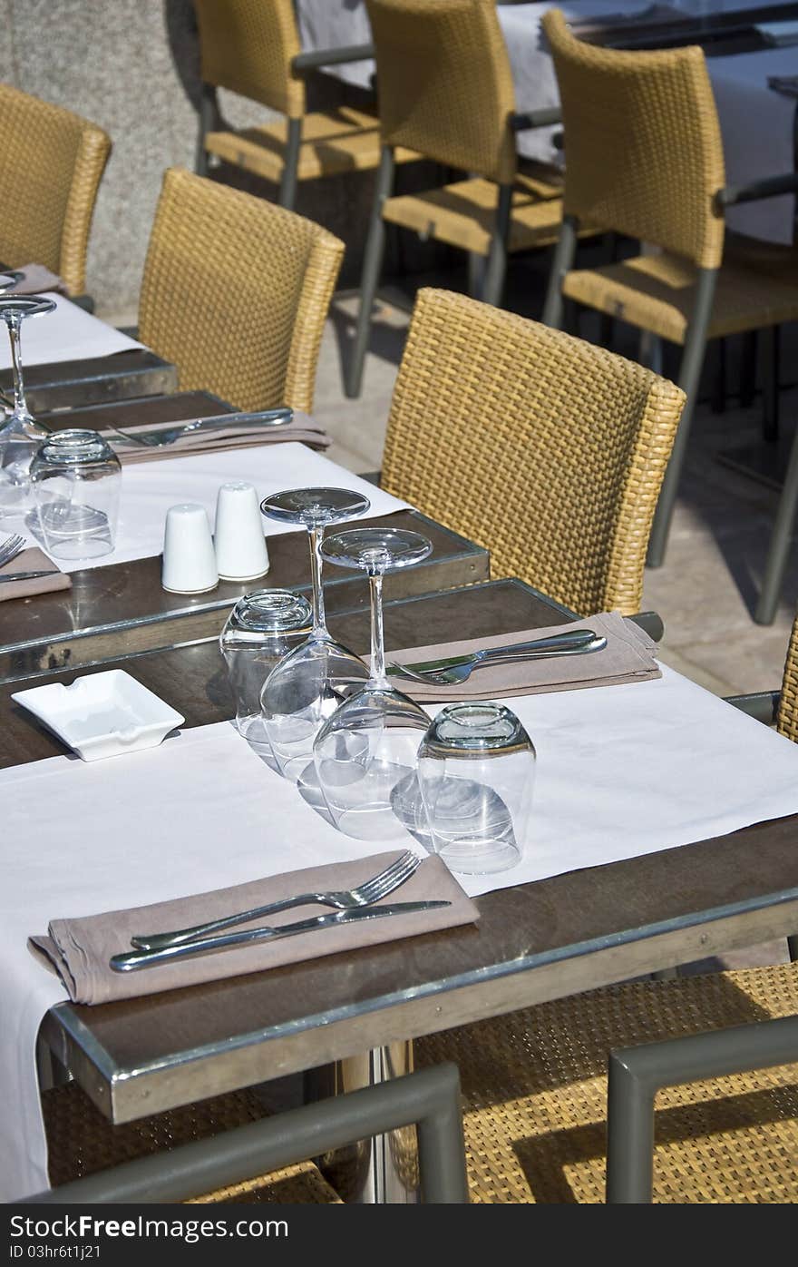 Covered table in the restaurant. Utensils for eating. Urban scene