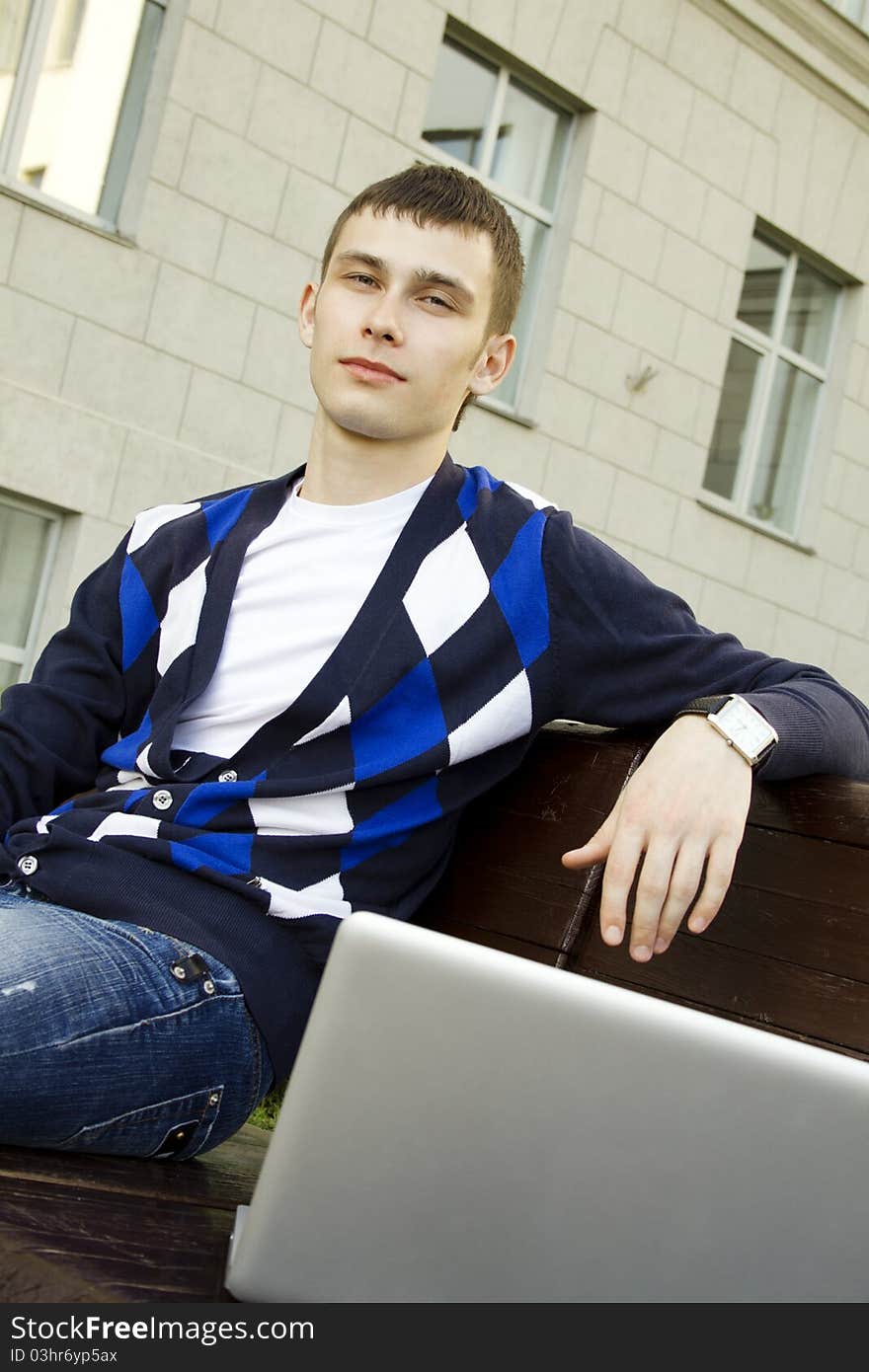 Close-up of a young male student with a laptop on campus. Close-up of a young male student with a laptop on campus