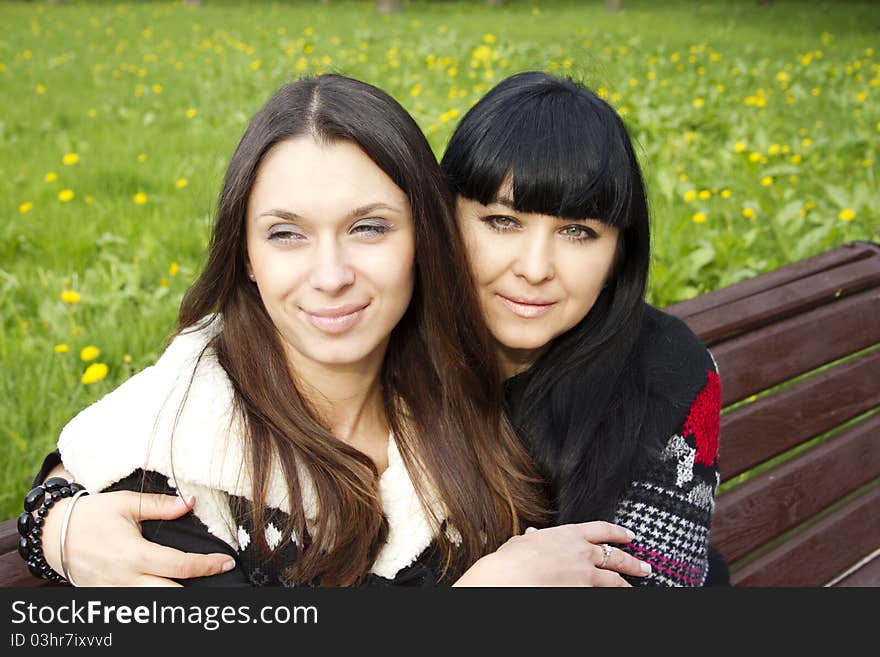 Portrait of smiling mother and teenage daughter hugging in the park happy. Portrait of smiling mother and teenage daughter hugging in the park happy