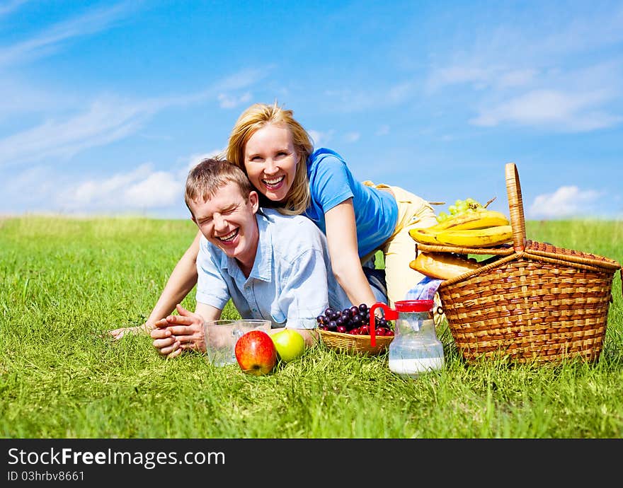 Happy young couple having a picnic outdoor on a summer day. Happy young couple having a picnic outdoor on a summer day