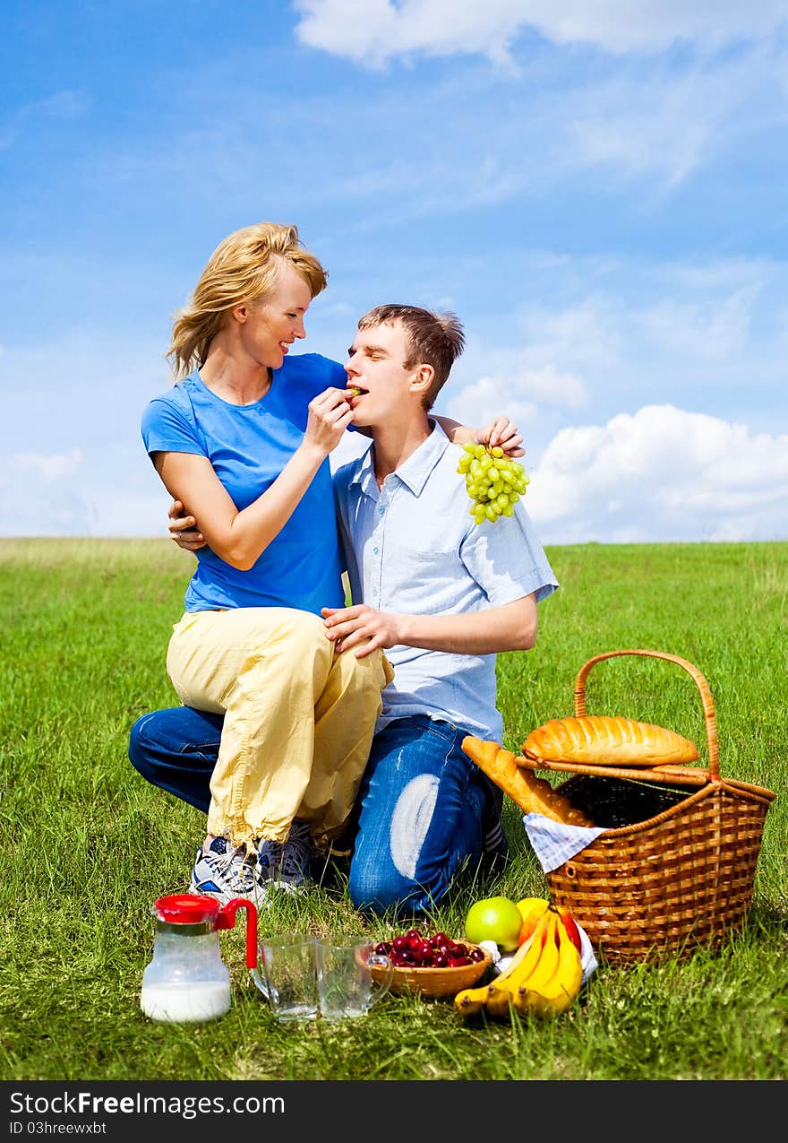 Happy young couple having a picnic outdoor on a summer day. Happy young couple having a picnic outdoor on a summer day