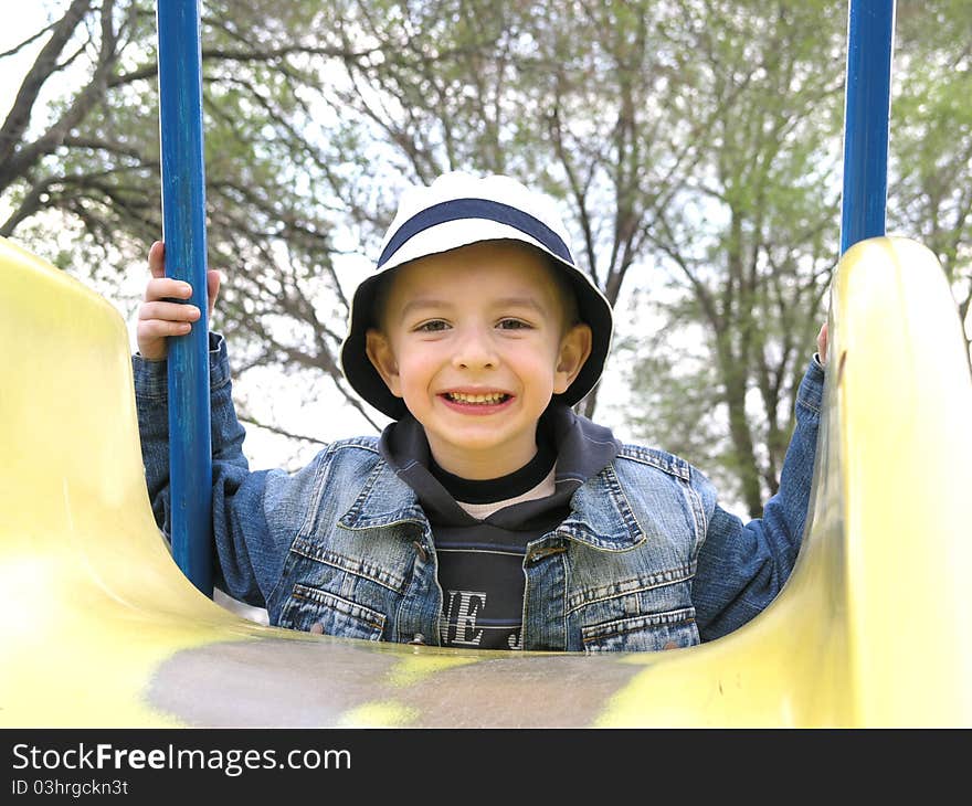 Happy boy wearing a yellow slide. Happy boy wearing a yellow slide