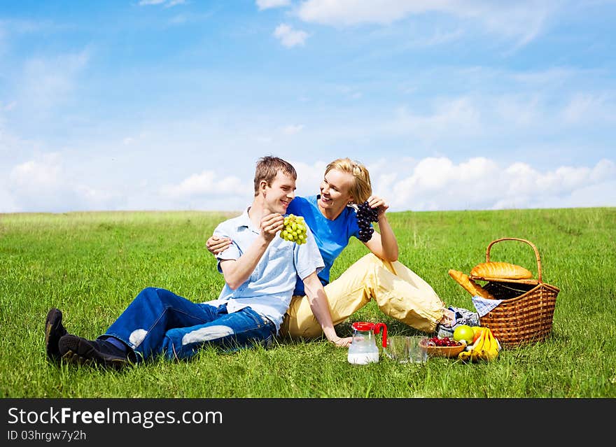 Happy young couple having a picnic outdoor on a summer day. Happy young couple having a picnic outdoor on a summer day