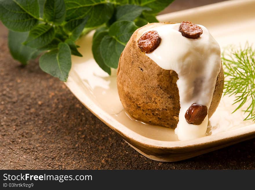 Baked potato with sour cream, greaves and dill