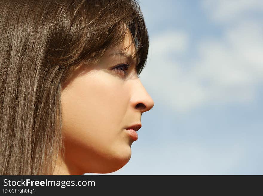 Young brunette girl, blue sky