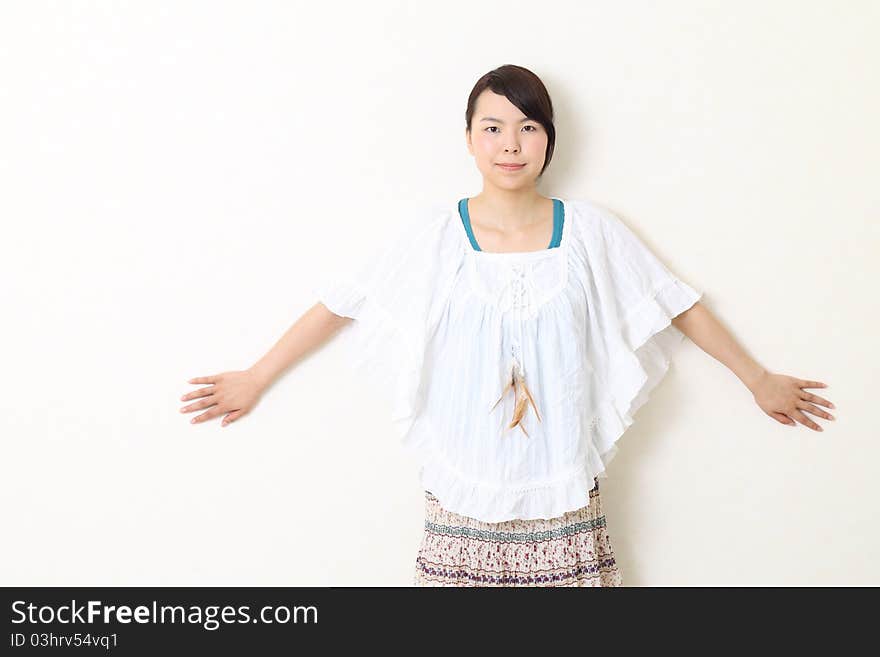 Young beautiful asian woman leaning against wall