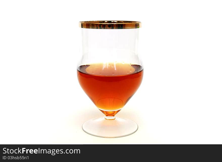 Glass with cognac standing on white background