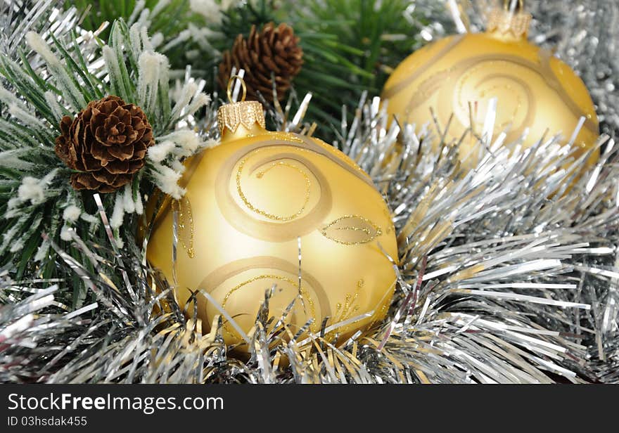 Christmas balls against the backdrop of tinsel with pine branches and cones. Christmas balls against the backdrop of tinsel with pine branches and cones