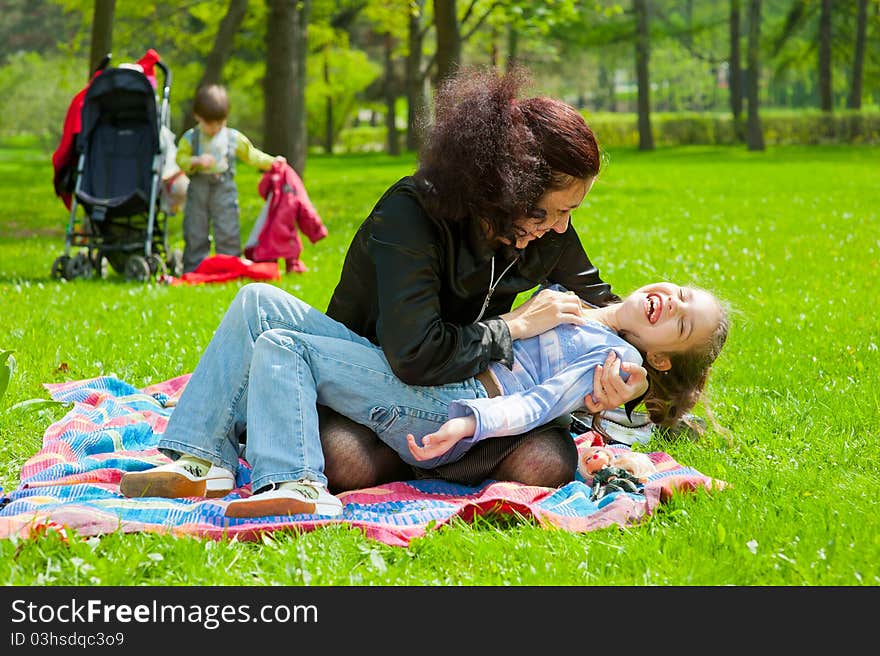 Mother with children resting and playing in the park