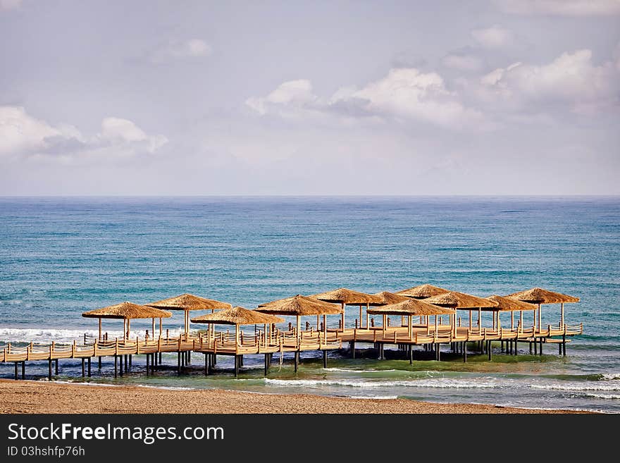 Wooden pier and straw umbrellas