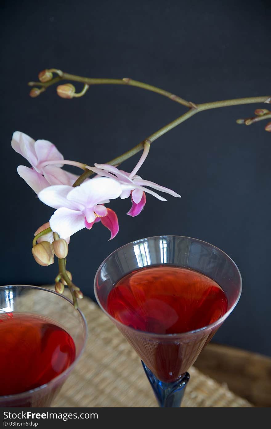 Close up of two glasses of red wine an flower on black background. Close up of two glasses of red wine an flower on black background.