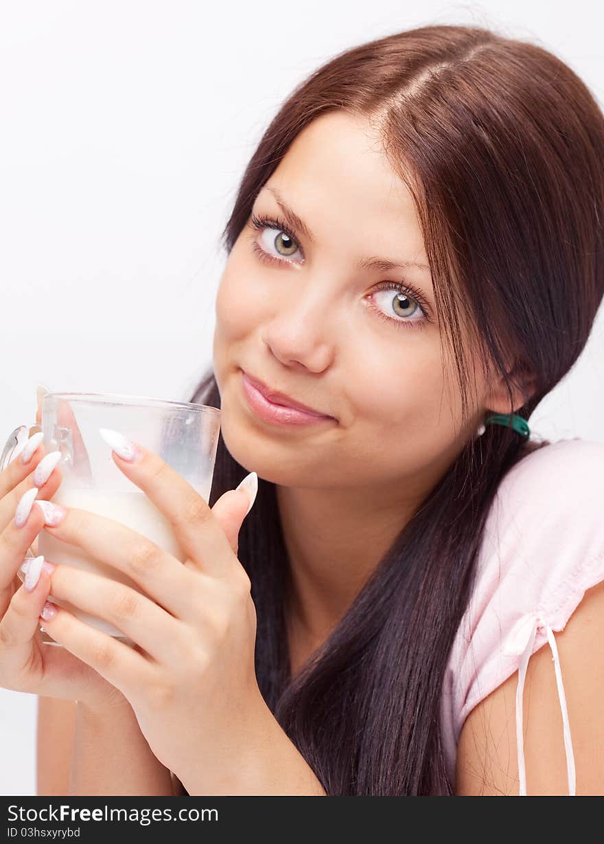 Pretty brunette girl drinking milk on the bed at home