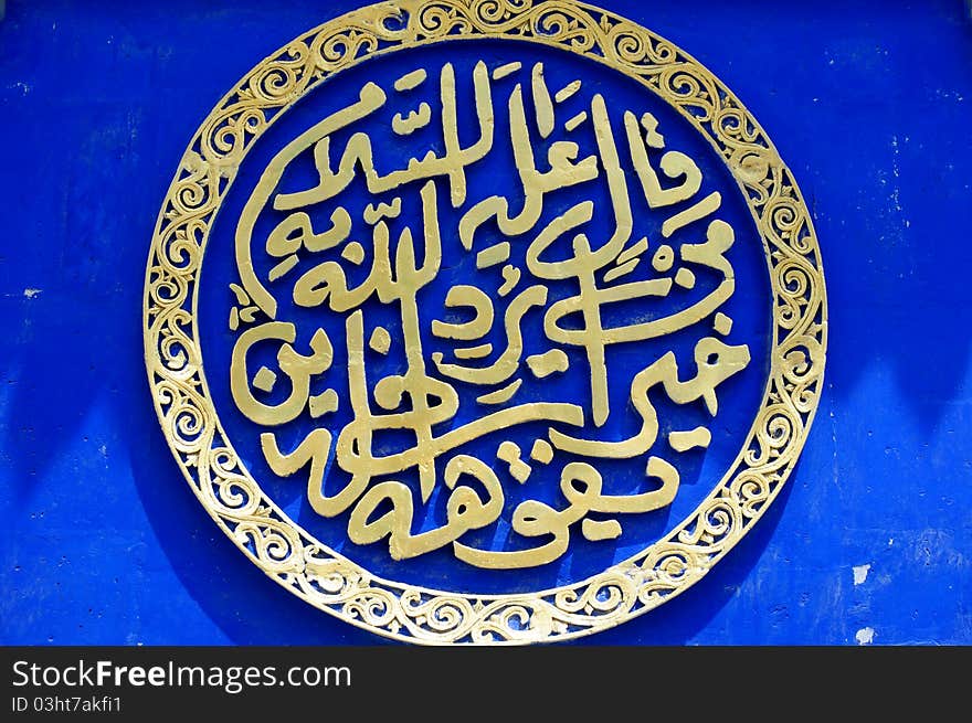 Islamic art,ancient arabian calligraphy on a blue wall background. Islamic art,ancient arabian calligraphy on a blue wall background.