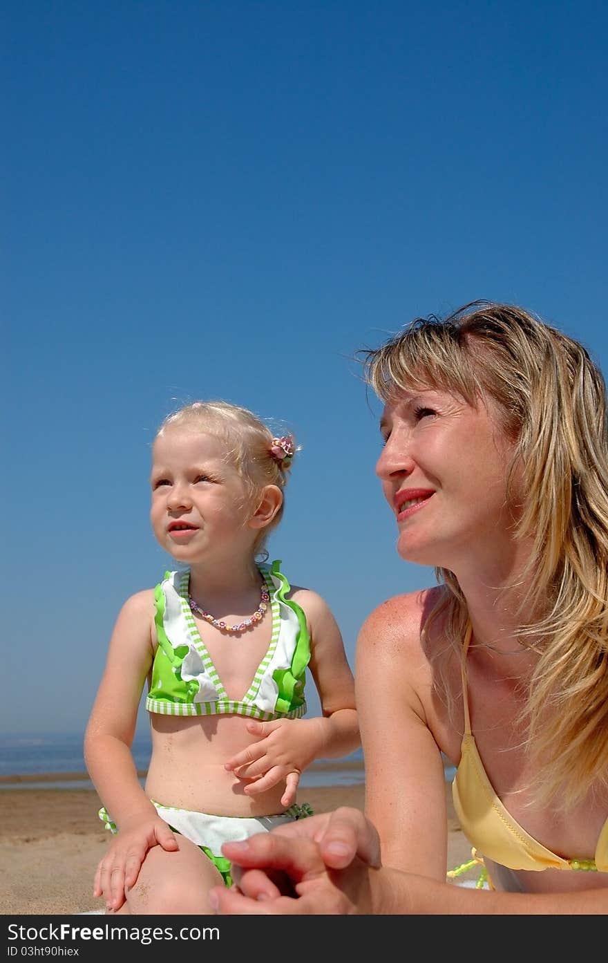 Happy woman and little girl on the beach