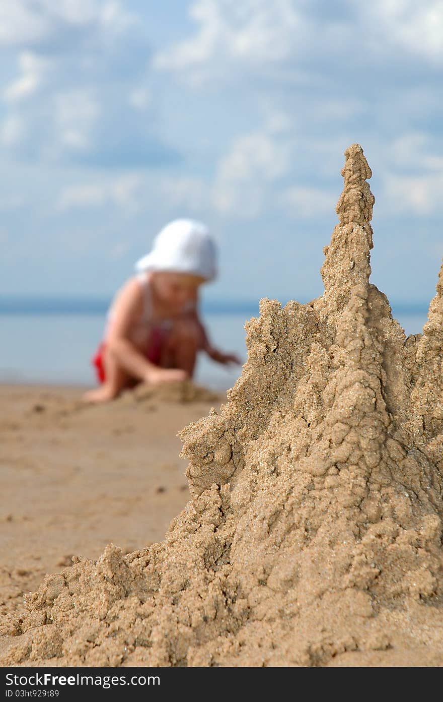 Sandcastle And Playing Child