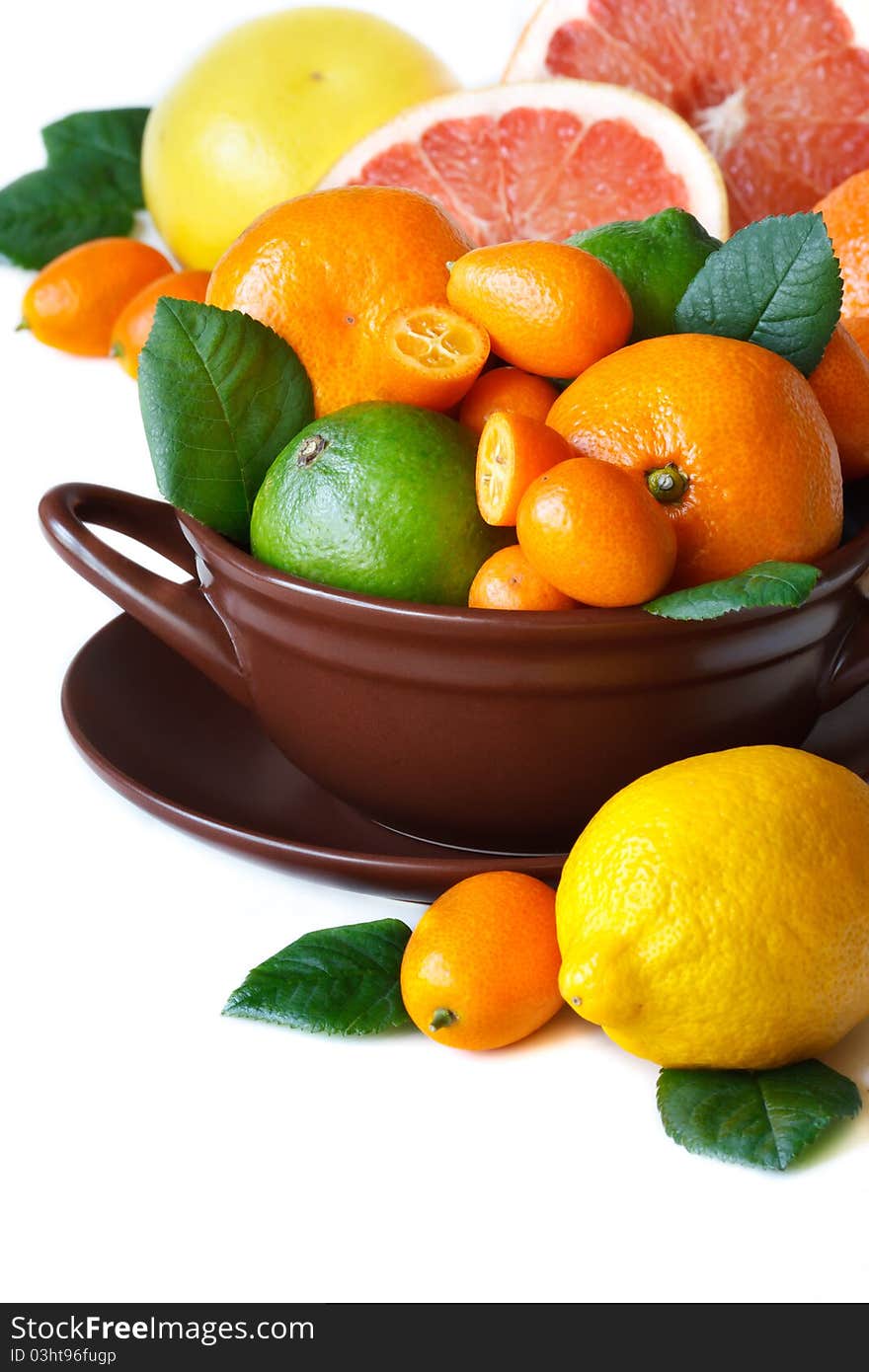 Colorful citrus fruit in a brown ceramic bowl. Colorful citrus fruit in a brown ceramic bowl.