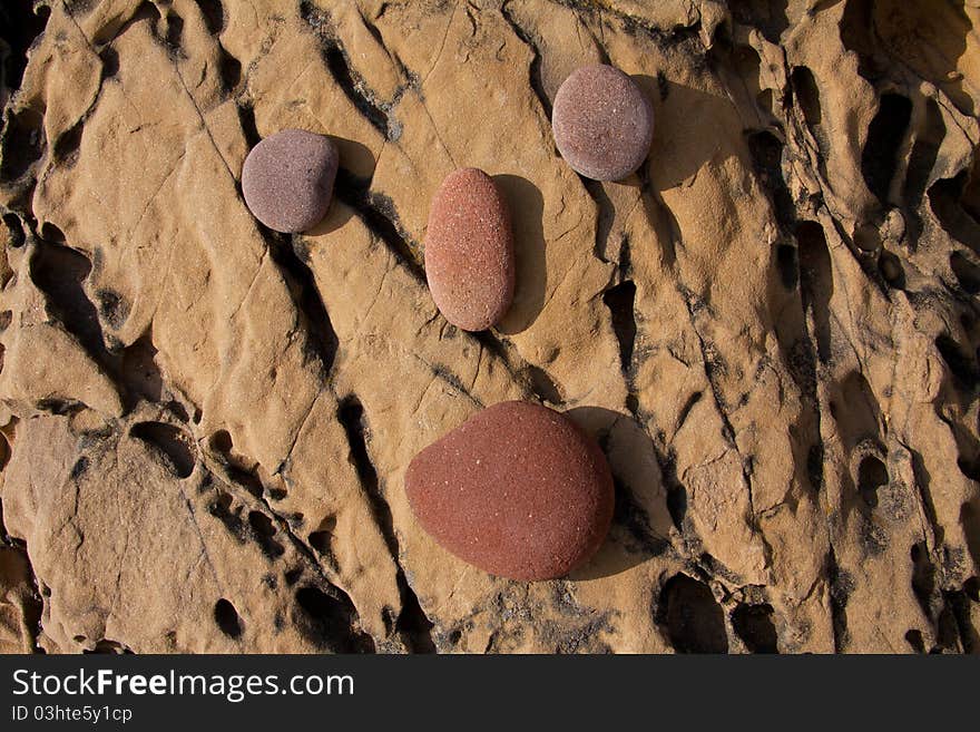 Round stones posed over a rock forming a stylized face. Round stones posed over a rock forming a stylized face