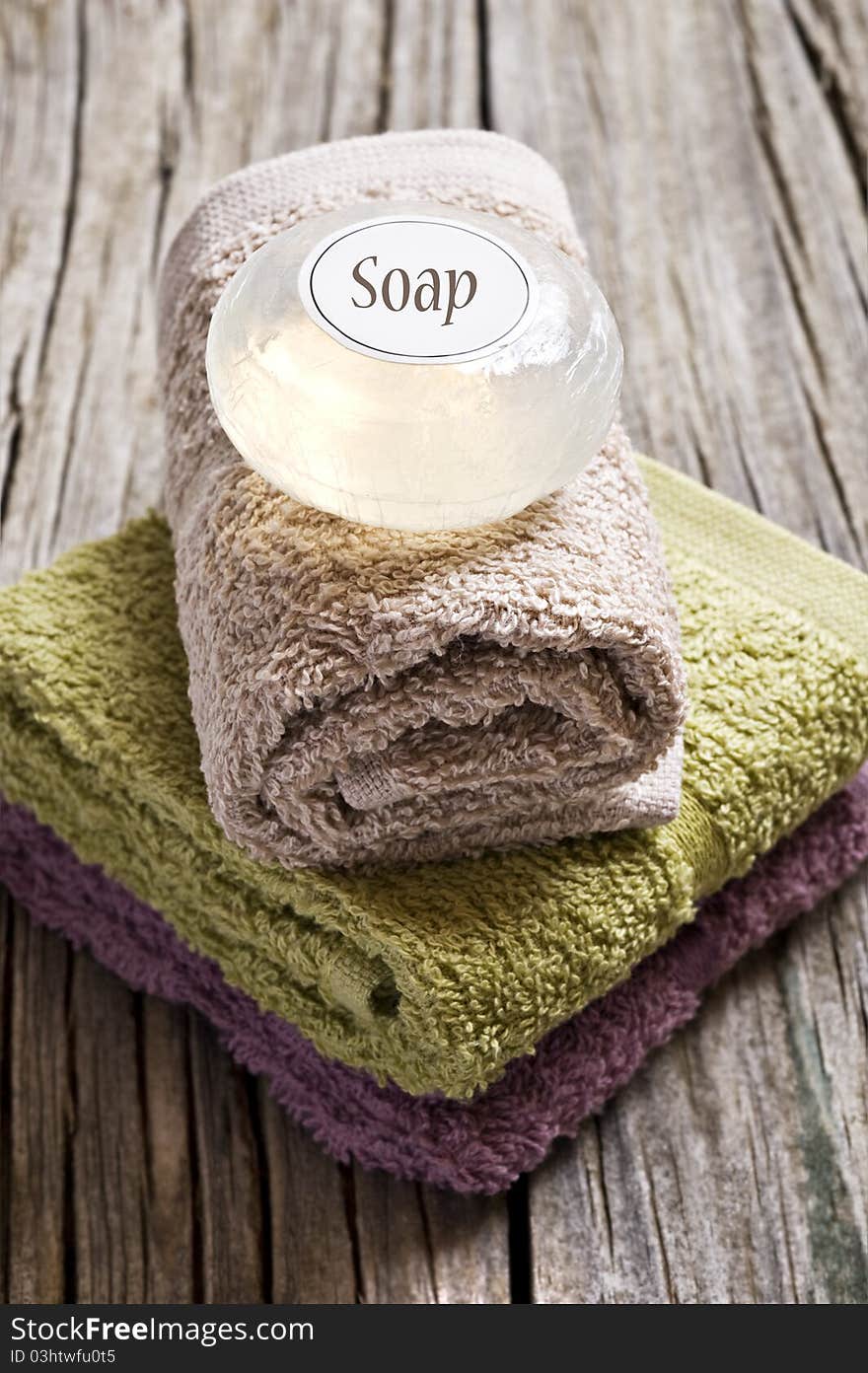 Fresh towels and glycerine soap on a rustic wooden surface. Fresh towels and glycerine soap on a rustic wooden surface