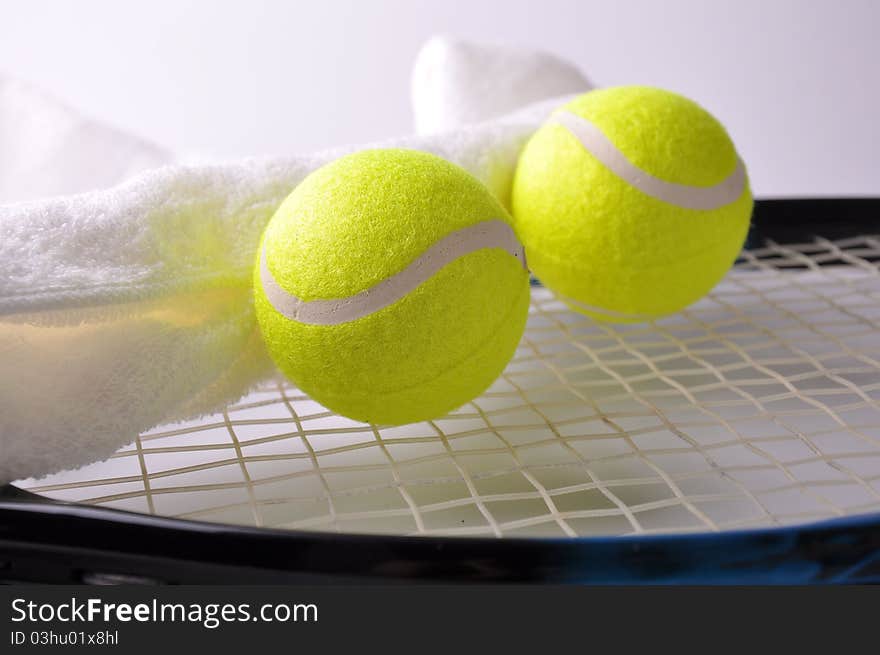 Two tennis balls and white towel on the racket isolated on white background.