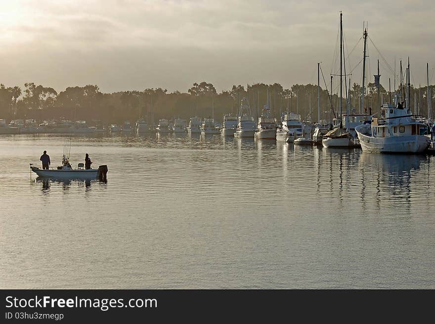 A small Fishing Boat drifts along as the early dawn mist slowly disappears. A small Fishing Boat drifts along as the early dawn mist slowly disappears.