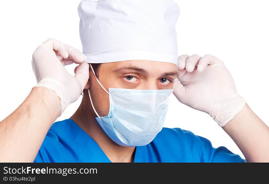 Portrait of a doctor putting on a mask and blue uniform. isolated on white background